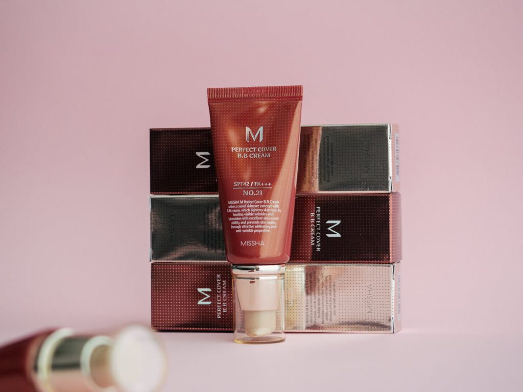 Stylish display of Missha Perfect Cover BB Cream on pink background with packaging.